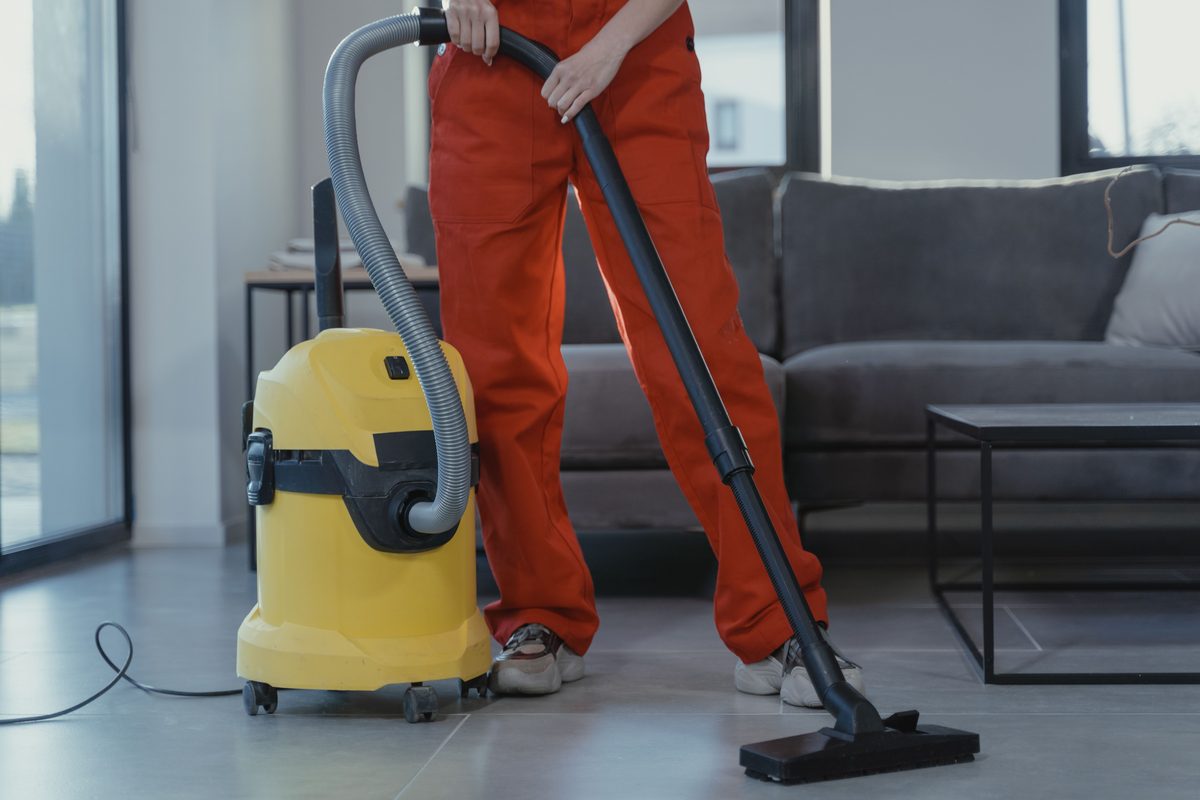 Técnico de limpieza con equipo profesional de extracción en un servicio a domicilio